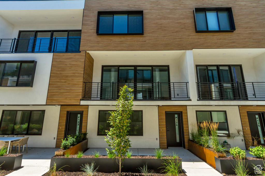 View of front of property with stucco siding and a balcony