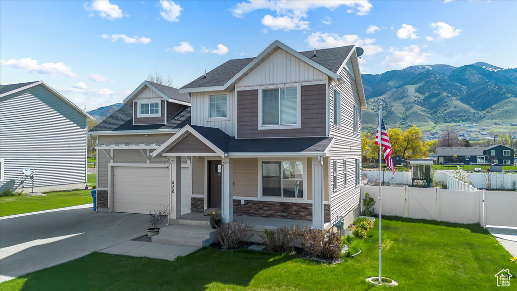 Craftsman-style home with a front lawn, fence, and driveway