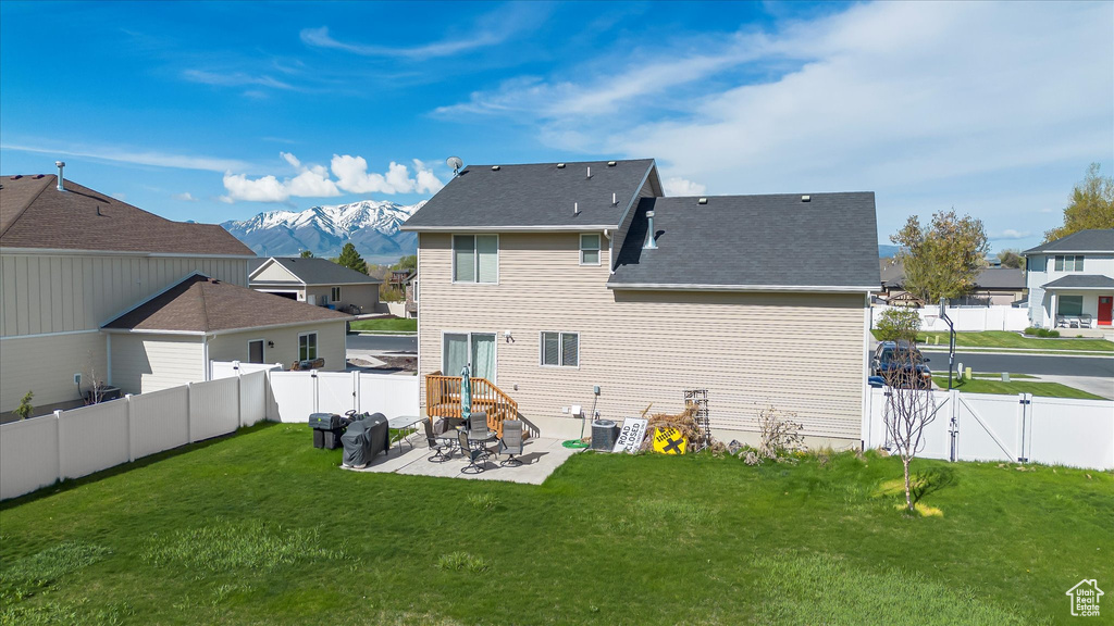 Rear view of property with a lawn, a patio, a gate, and a fenced backyard