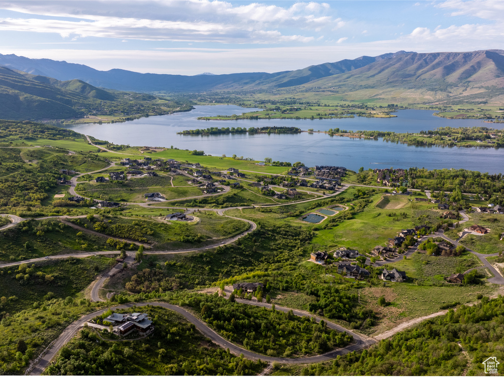 Aerial view of property and surrounding area with a water and mountain view
