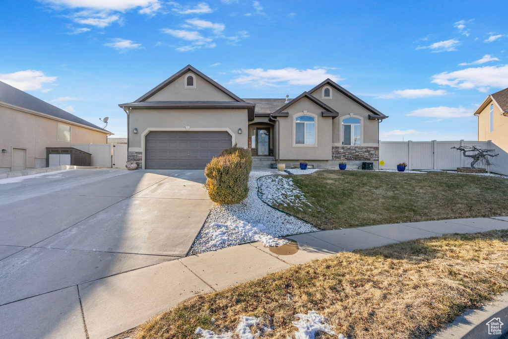 Single story home featuring a garage and a front lawn