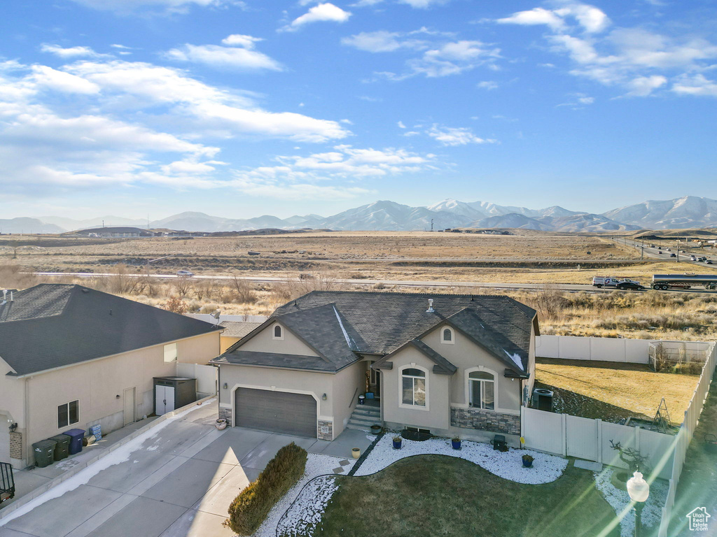 View of front of house with a mountain view and a garage