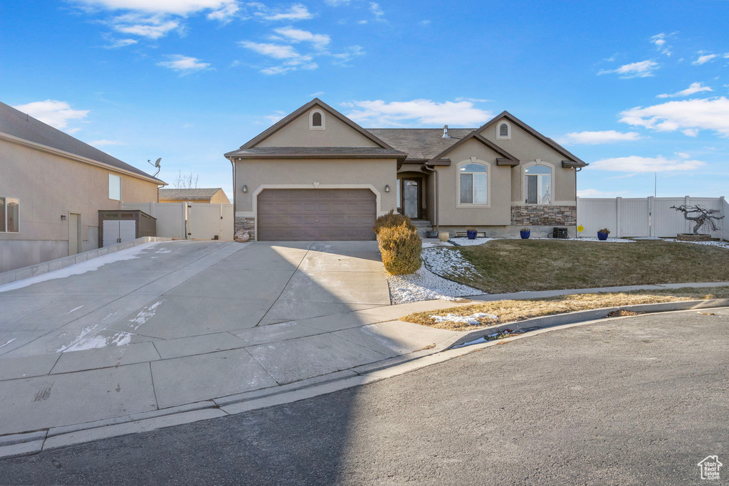 Single story home featuring a garage and a front yard