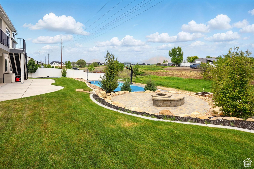 View of yard with a patio, a fire pit, and fence