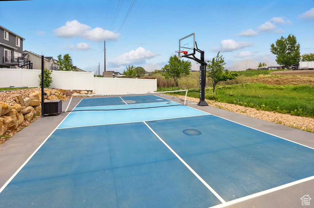 View of sport court featuring a tennis court and fence