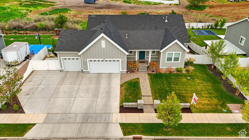 View of front of home with concrete driveway, board and batten siding, and roof with shingles