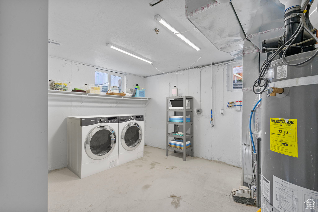 Washroom featuring water heater and independent washer and dryer