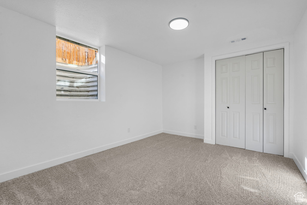 Unfurnished bedroom featuring a closet and carpet