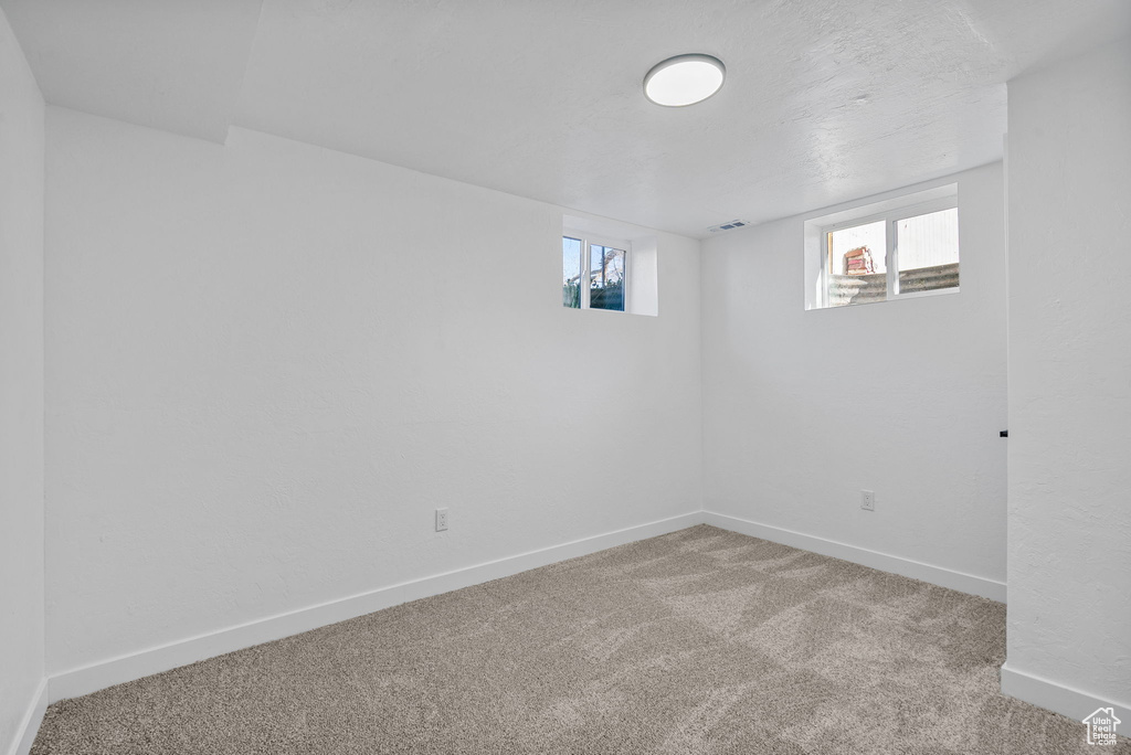 Carpeted empty room featuring plenty of natural light