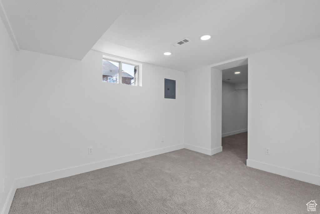 Basement featuring electric panel and carpet