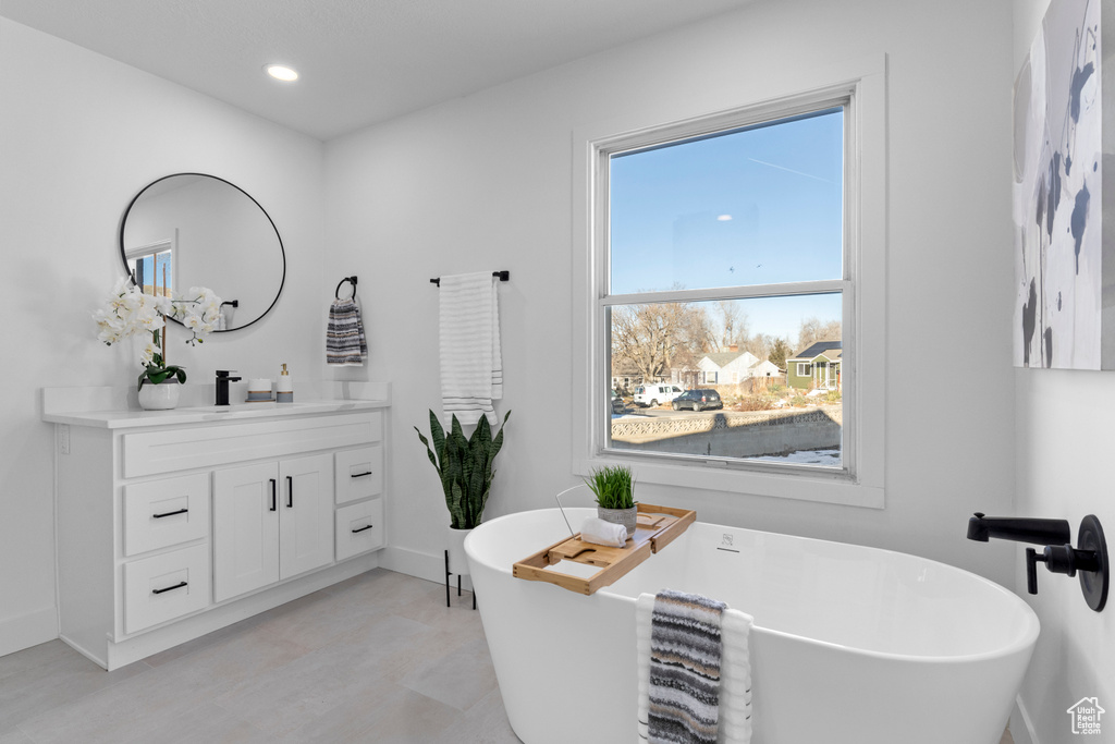 Bathroom with vanity, a bathtub, and plenty of natural light