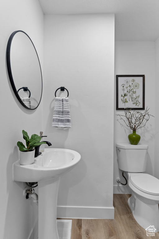 Bathroom featuring hardwood / wood-style floors and toilet