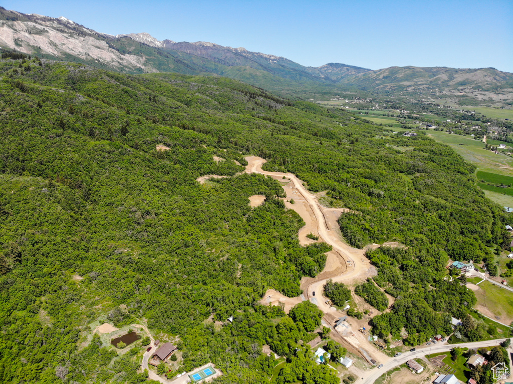 Aerial view of property's location with a mountainous background and a heavily wooded area