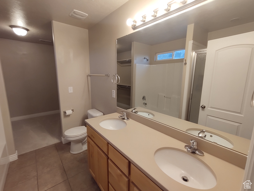 Bathroom featuring tile patterned flooring, an enclosed shower, and a sink