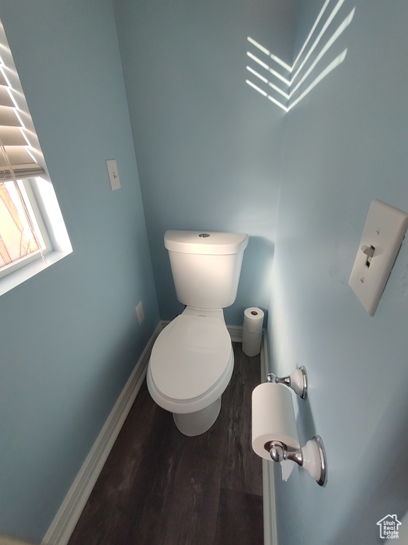 Bathroom with toilet, baseboards, and wood finished floors