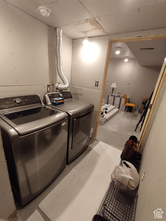 Clothes washing area featuring laundry area and washer and clothes dryer