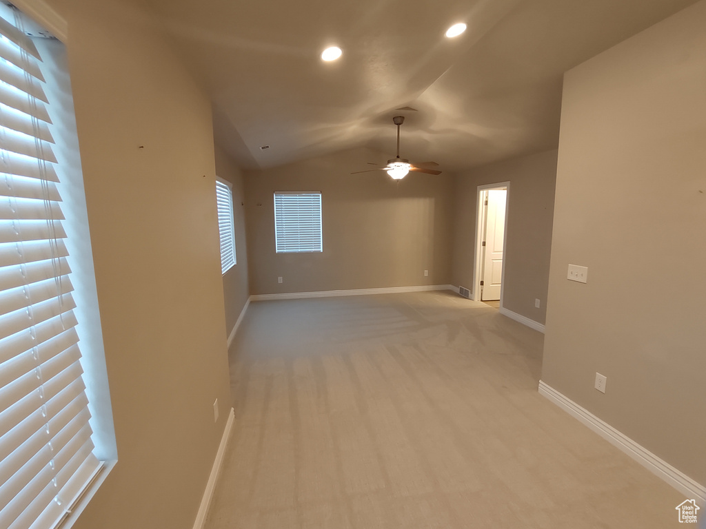 Empty room with recessed lighting, baseboards, light colored carpet, ceiling fan, and vaulted ceiling