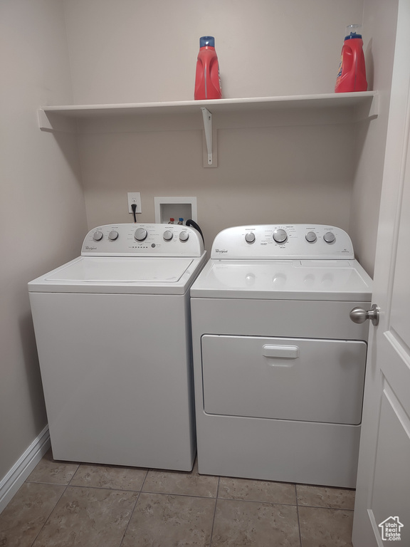 Laundry area with laundry area, light tile patterned flooring, baseboards, and washer and clothes dryer