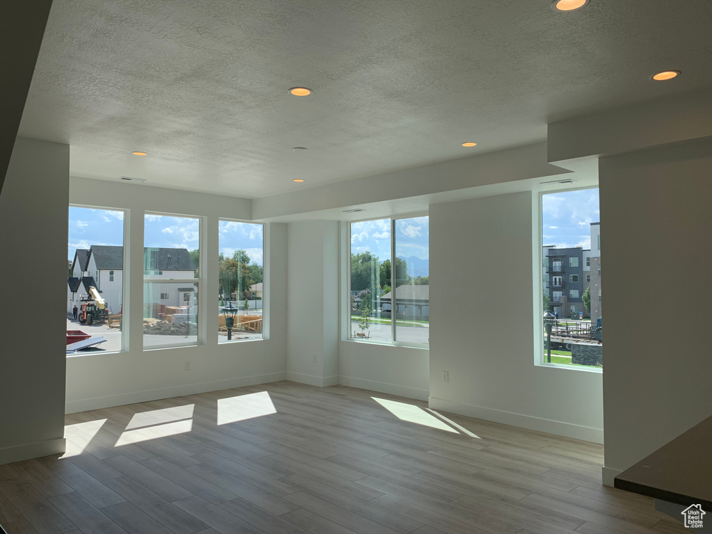 Spare room with light hardwood / wood-style flooring and a textured ceiling