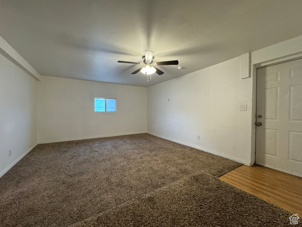 Spare room featuring carpet and ceiling fan