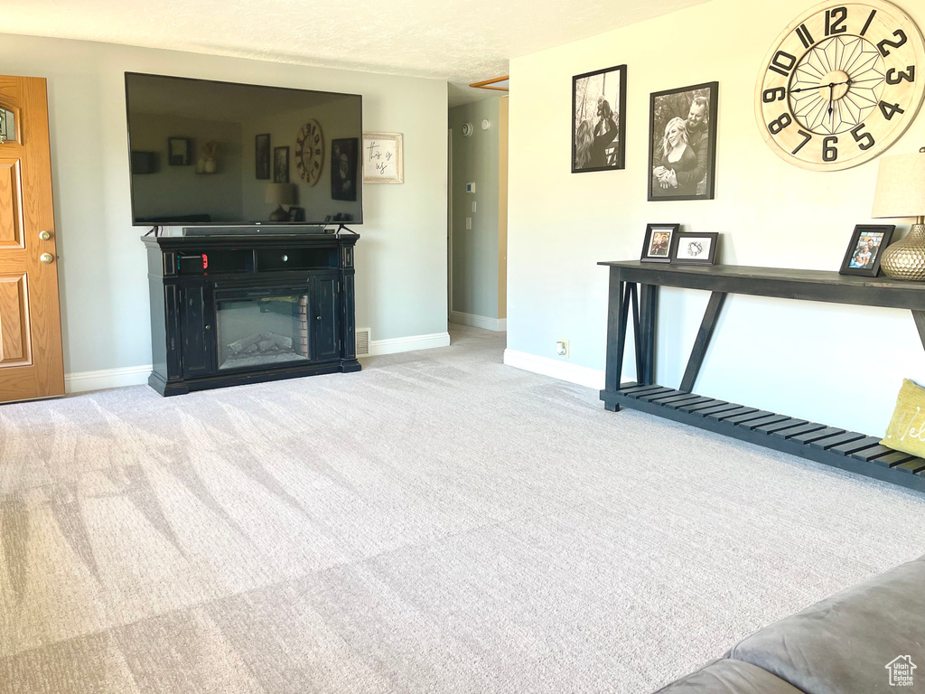 Unfurnished living room featuring light carpet