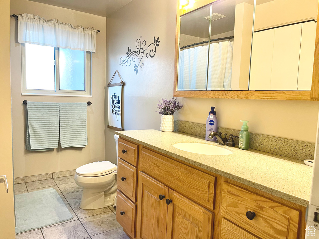 Bathroom with tile patterned floors, vanity, and toilet