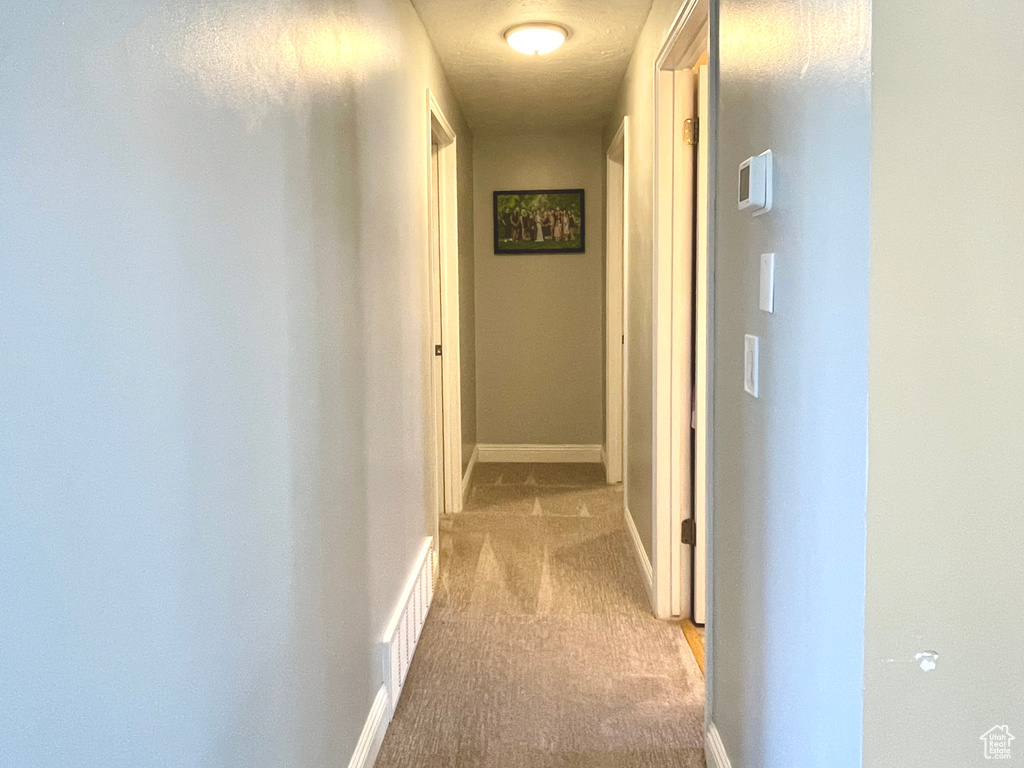 Hall featuring light colored carpet