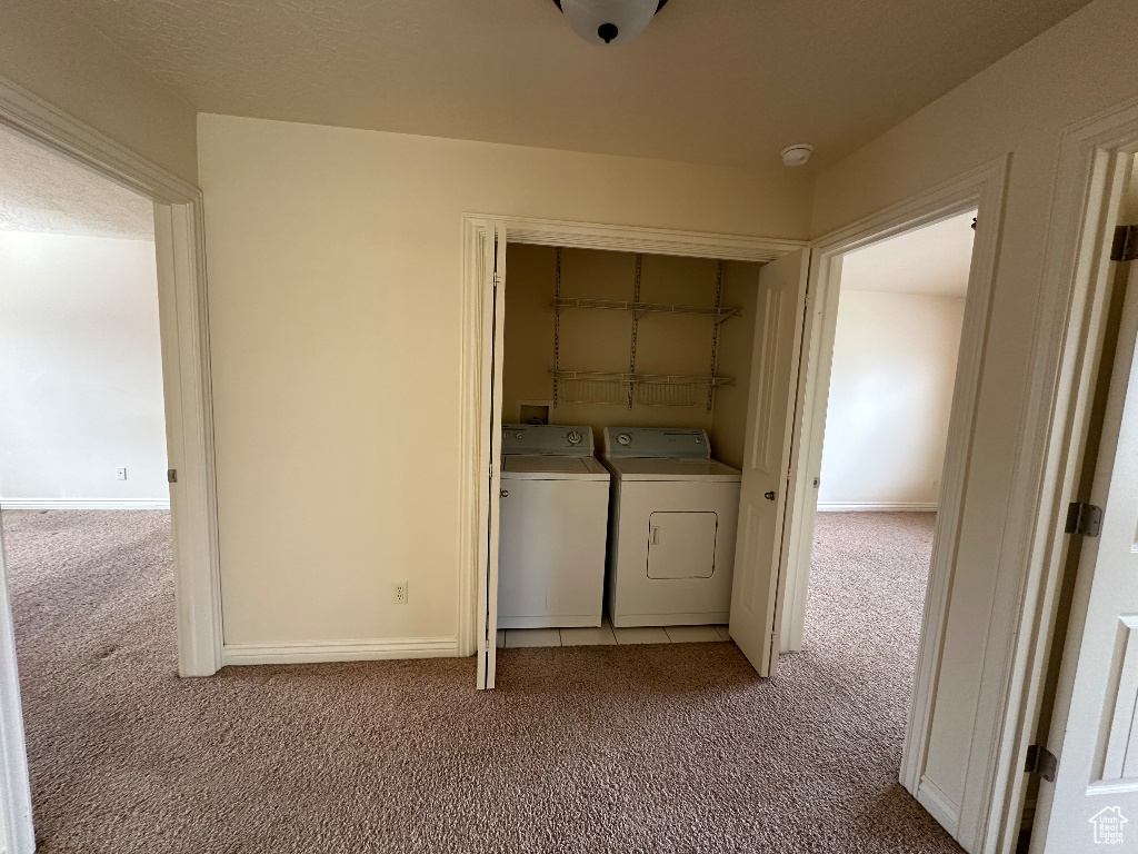 Laundry area featuring light carpet and washing machine and clothes dryer