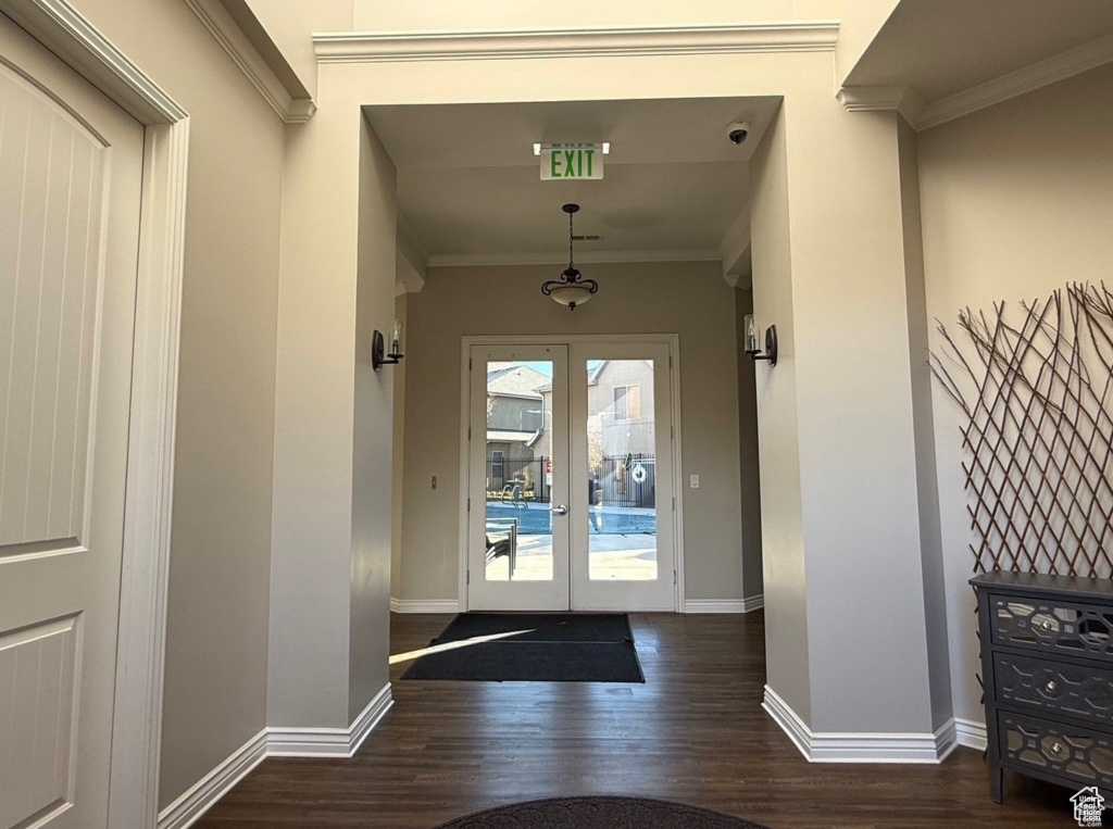 Doorway to outside with ornamental molding, dark hardwood / wood-style floors, and french doors