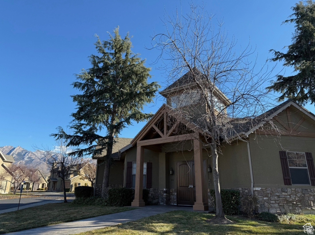 View of front of property featuring a mountain view and a front yard