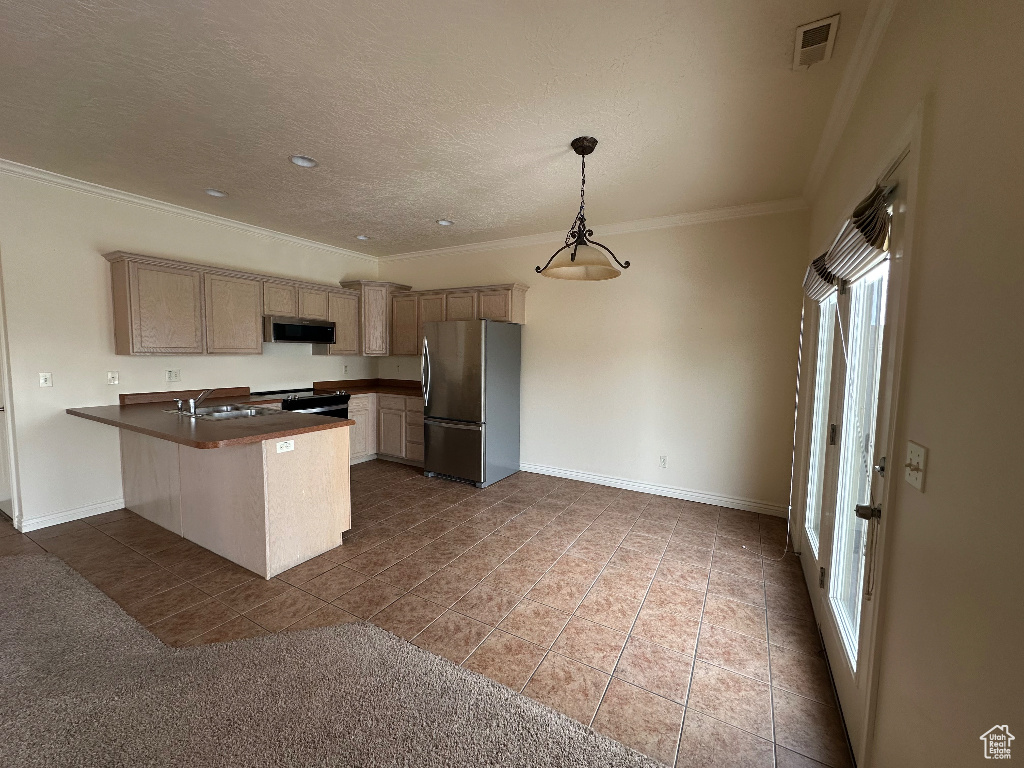 Kitchen with light brown cabinetry, stainless steel fridge, hanging light fixtures, kitchen peninsula, and crown molding