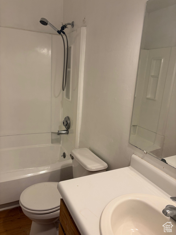 Full bathroom featuring toilet, vanity, bathtub / shower combination, and wood finished floors