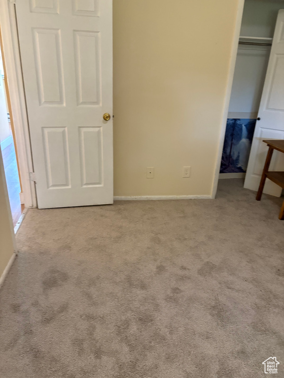 Unfurnished bedroom with carpet, a closet, and baseboards