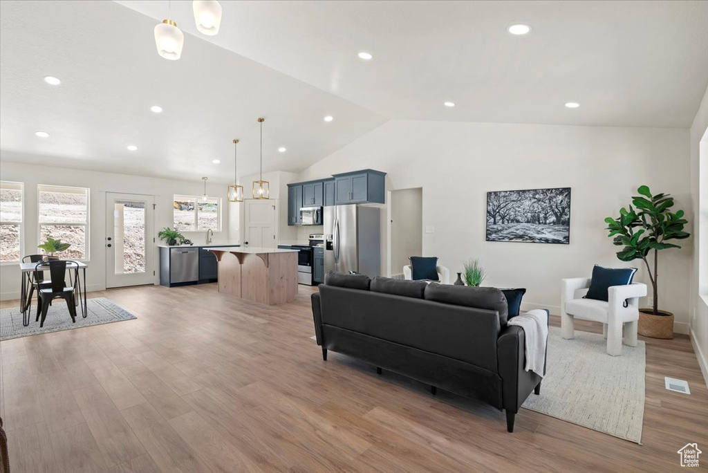 Living area featuring recessed lighting, visible vents, light wood-type flooring, and vaulted ceiling