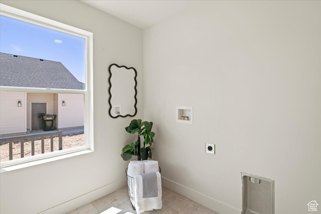 Washroom featuring washer hookup, laundry area, hookup for an electric dryer, baseboards, and a wood stove