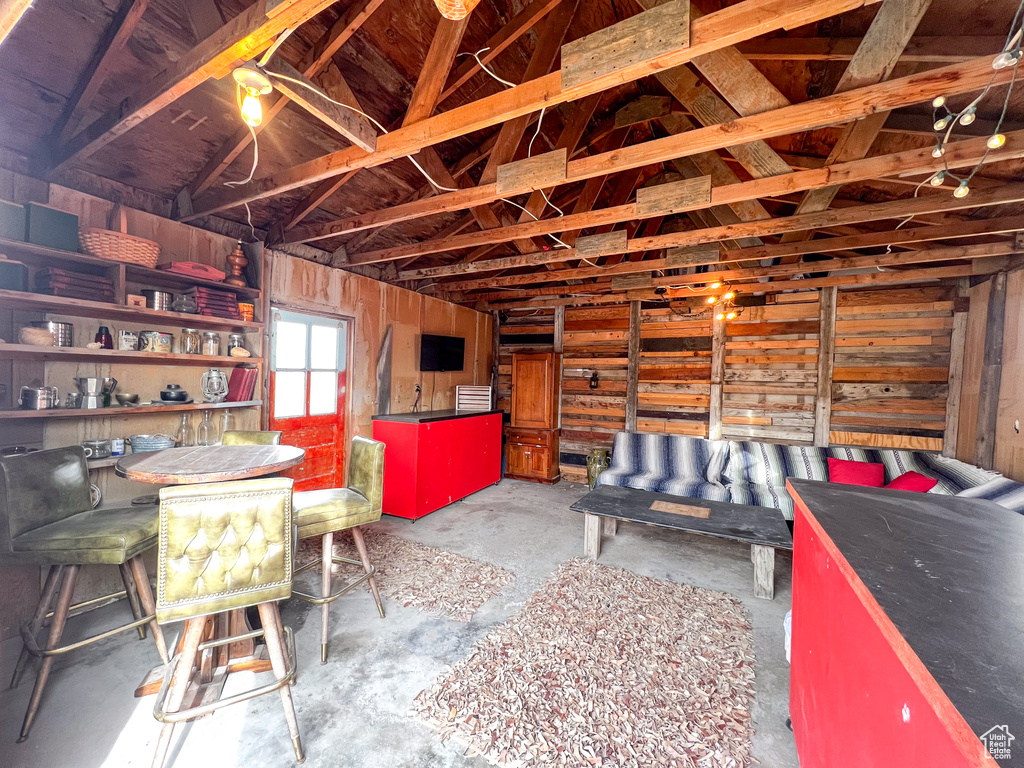 Misc room featuring vaulted ceiling and concrete floors