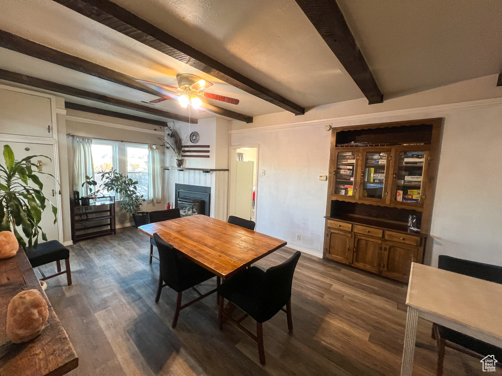 Dining area featuring beamed ceiling, ceiling fan, and dark hardwood / wood-style flooring