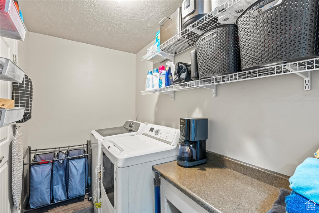 Laundry area with separate washer and dryer and a textured ceiling