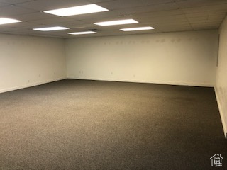 Empty room with carpet floors and a paneled ceiling