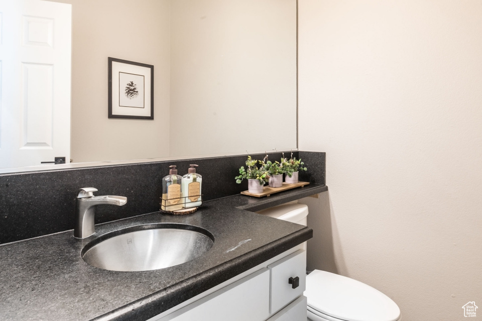 Bathroom with vanity, toilet, and backsplash