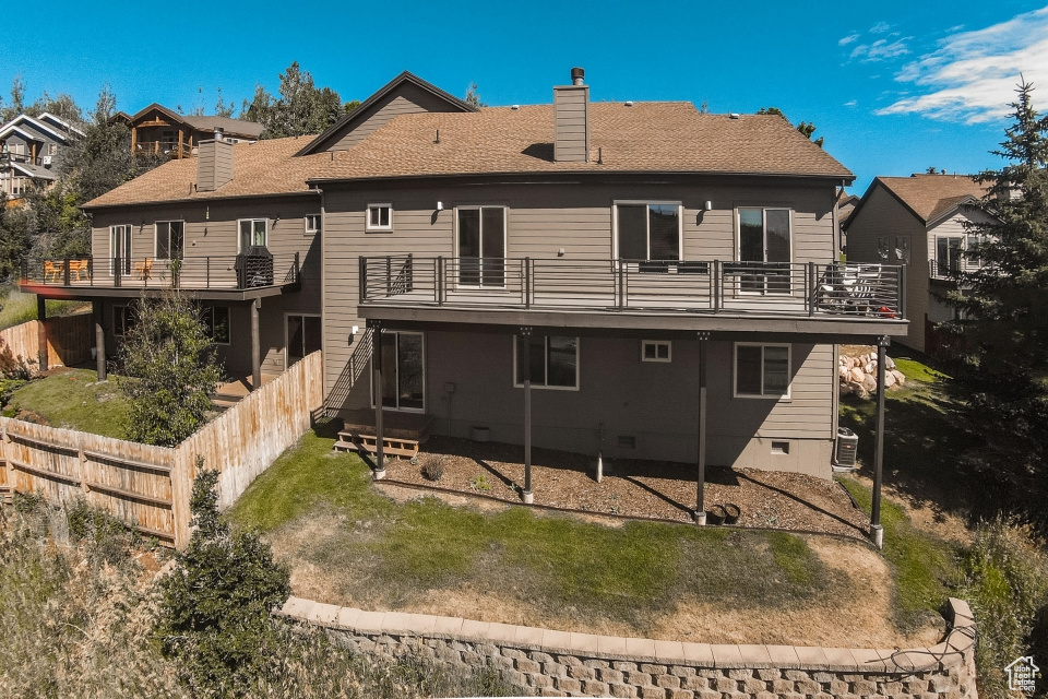 Rear view of property featuring central AC and a balcony