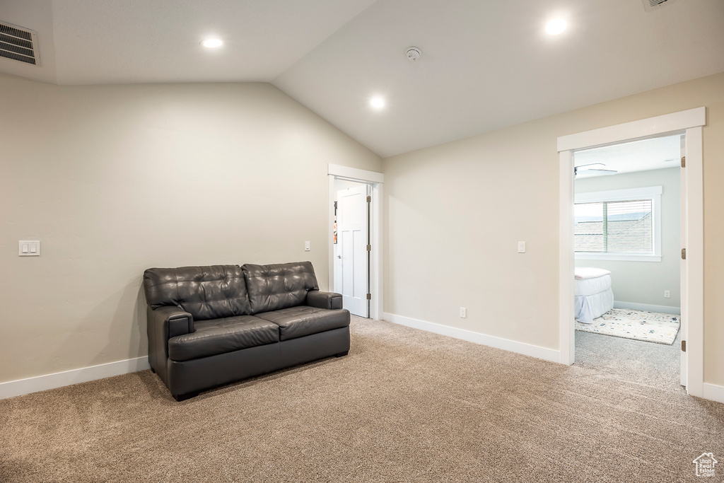 Living area with lofted ceiling and carpet