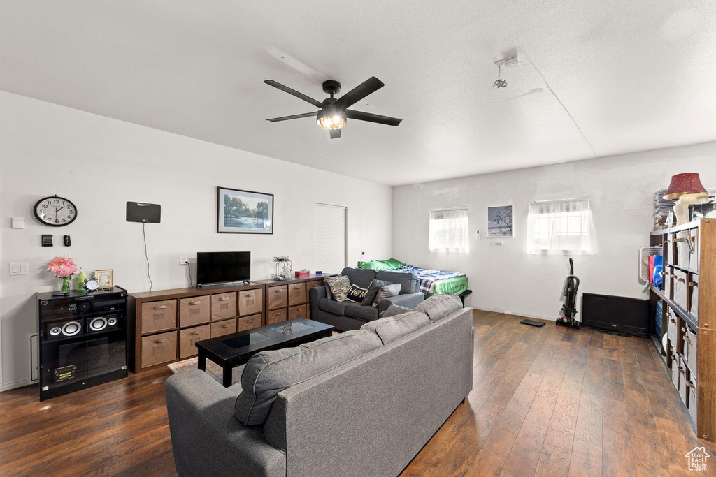 Living room with dark hardwood / wood-style flooring and ceiling fan