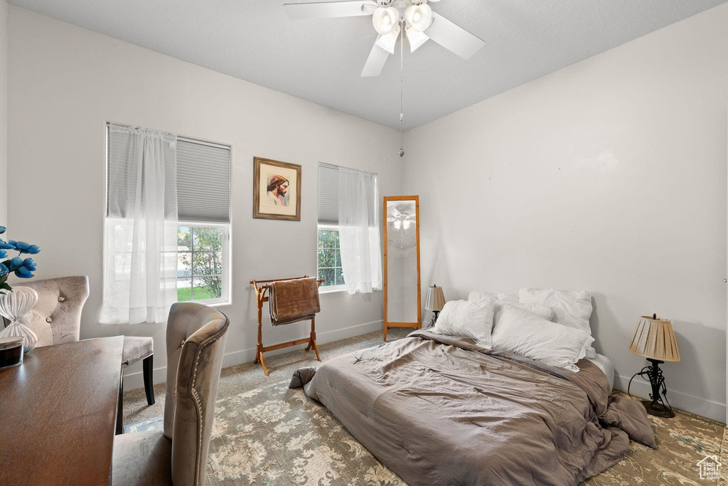 Bedroom with ceiling fan and light carpet