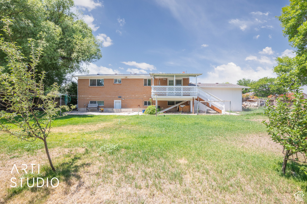 Back of property featuring a yard and a deck