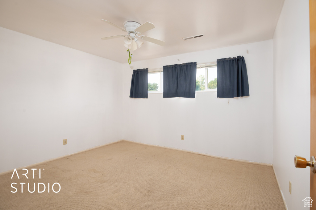 Carpeted spare room featuring ceiling fan