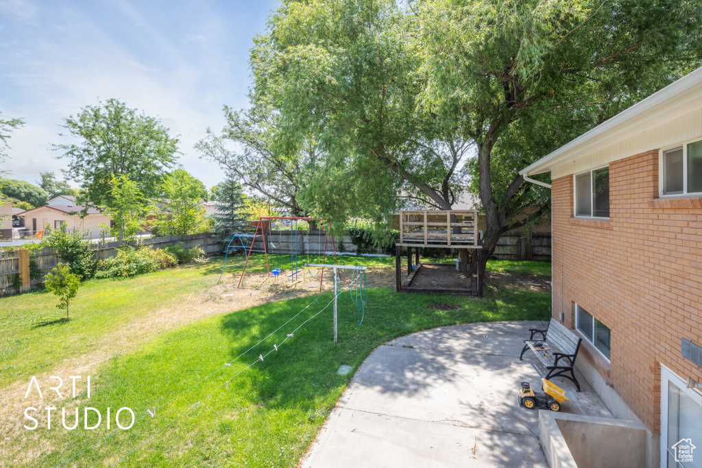 View of yard featuring a trampoline, a playground, and a patio area