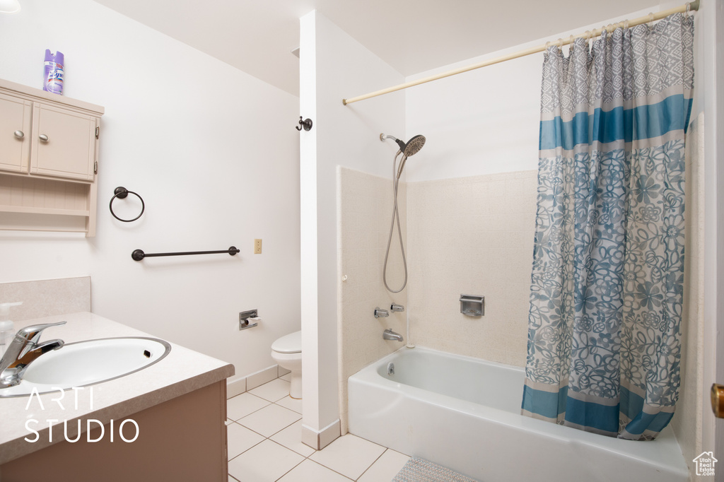 Full bathroom featuring shower / tub combo with curtain, vanity, toilet, and tile patterned flooring