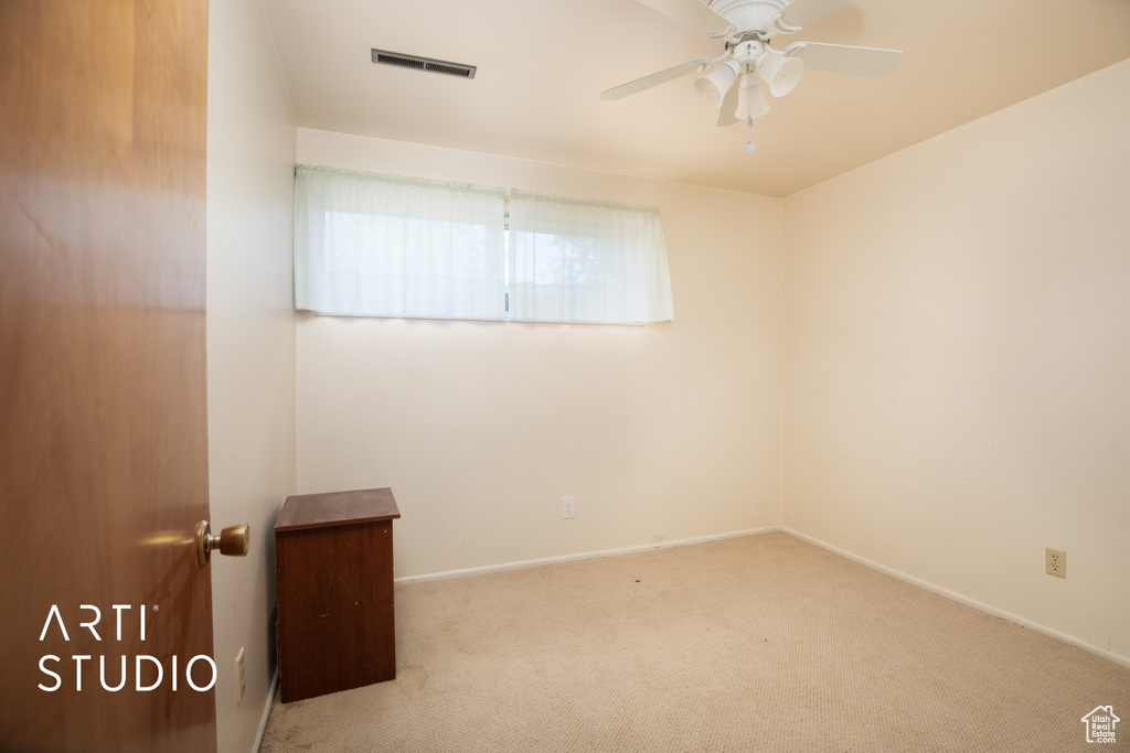 Spare room featuring light carpet and ceiling fan