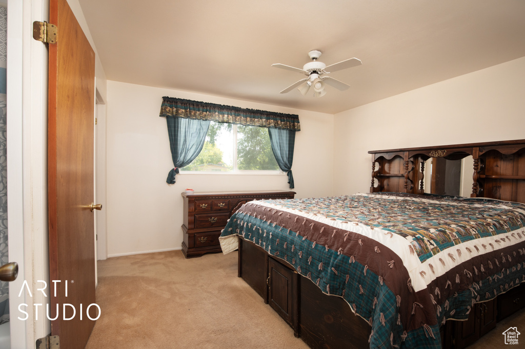 Carpeted bedroom featuring ceiling fan